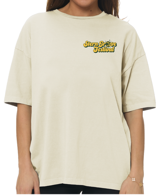 A person wearing an oversized cream-colored t-shirt with a yellow and black 'Stay Freeze School' graphic on the left chest, shown against a plain white background.